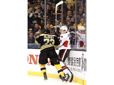Charlie McAvoy of the Boston Bruins checks Ryan Dzingel of the Ottawa Senators into the boards during the second period.