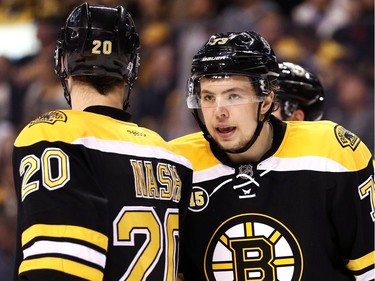 Charlie McAvoy of the Boston Bruins talks with Riley Nash during the second period.