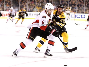 Chris Wideman of the Ottawa Senators and Dominic Moore battle for control of the puck.