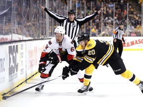 Riley Nash of the Boston Bruins and Mark Stone of the Ottawa Senators battle for control of the puck.