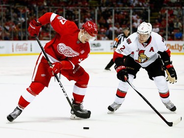 DETROIT, MI - APRIL 03:  Evgeny Svechnikov #37 of the Detroit Red Wings tries to control the puck next to Dion Phaneuf #2 of the Ottawa Senators during the second period at Joe Louis Arena on April 3, 2017 in Detroit, Michigan.