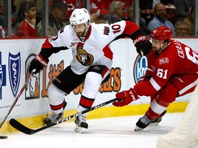 Tom Pyatt #10 of the Ottawa Senators tries to get around the stick of Xavier Ouellet #61 of the Detroit Red Wings during the second period at Joe Louis Arena on April 3, 2017 in Detroit, Michigan.