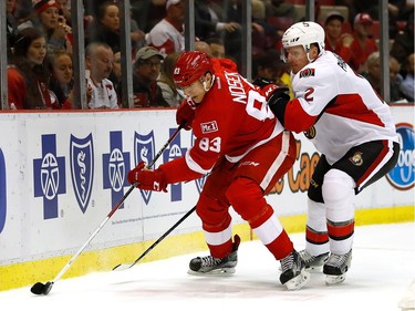 DETROIT, MI - APRIL 03:  Tomas Nosek #83 of the Detroit Red Wings tries to get control of the puck in front of Dion Phaneuf #2 of the Ottawa Senators during the first period at Joe Louis Arena on April 3, 2017 in Detroit, Michigan.