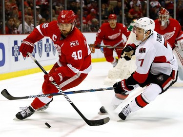 DETROIT, MI - APRIL 03:  Henrik Zetterberg #40 of the Detroit Red Wings tries to control the puck next to Kyle Turris #7 of the Ottawa Senators during the second period at Joe Louis Arena on April 3, 2017 in Detroit, Michigan.