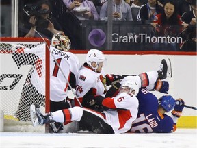 Senators goalie Mike Condon gets tangled up with teammates Mark Borowiecki and Chris Wideman (6) and the Islanders' Andrew Ladd behind the net during the first period of Sunday's contest at the Barclays Center.