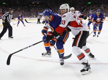 NEW YORK, NY - APRIL 09: Fredrik Claesson #33 of the Ottawa Senators holds on to Alan Quine #10 of the New York Islanders during the second period at the Barclays Center on April 9, 2017 in the Brooklyn borough of New York City.