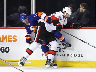 NEW YORK, NY - APRIL 09: Ben Harpur #67 of the Ottawa Senators hits Thomas Hickey #14 of the New York Islanders into the boards during the second period at the Barclays Center on April 9, 2017 in the Brooklyn borough of New York City.