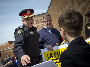 Police Chief Charles Bordeleau and Mayor Jim Watson were speaking with a young boy before the community safety march kicked off on Jasmine Crescent Sunday April 9, 2017.   Ashley Fraser/Postmedia