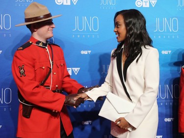 Ruth B greets RCMP constable Zachary MacMillan before winning Breakthrough Artist of the Year as musical talent take to the red carpet at the Juno Awards held on Sunday at the Canadian Tire Centre.