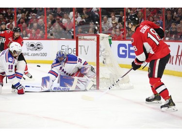 Ryan Dzingel passes to Alex Burrows in front of goalie Henrik Lundqvist in the first period.