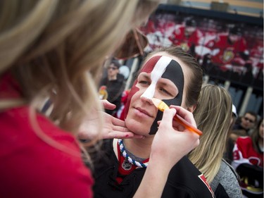 Sarah Seaton gets her face painted in front of the Canadian Tire Centre before the game.