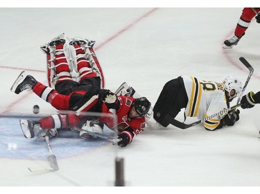 The Ottawa Senators' Craig Anderson and Erik Karlsson collide as the Boston Bruins' Tim Schaller scores during second period.