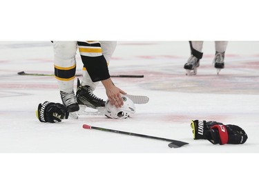 A Boston Bruins player picks up his helmet at the Canadian Tire Centre in Game 2.