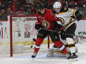 Senators winger Zack Smith is still battling for position with Bruins defenceman Charlie McAvoy as Chris Wideman's shot enters the net for a goal in the third period of Saturda's game. Tony Caldwell/Postmedia