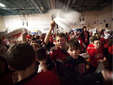 Students at A. Lorne Cassidy Elementary School wave Senators towels during a rally with former players Chris Phillips and Shaun Van Allen.