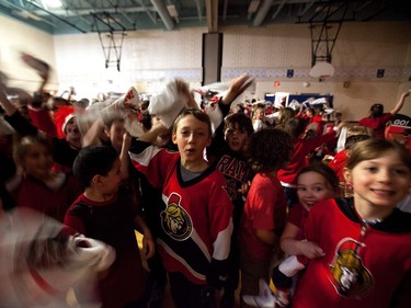 Students at A. Lorne Cassidy Elementary School wave Senators towels during a rally with former players Chris Phillips and Shaun Van Allen.