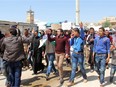 Syrian residents of Khan Sheikhun hold placards and pictures on April 7, 2017 during a protest condemning a chemical weapons attack on their town that killed at least 86 people, among them 30 children, and left hundreds suffering symptoms including convulsions, vomiting or foaming at the mouth.