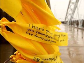 The fence rails of the Armstrong/Strandherd Road bridge in Barrhaven have blossomed with thousands of hand-tied yellow ribbons in remembrance of the sacrifice our men and women in uniform made at Vimy Ridge. (Photo: Julie Oliver/Postmedia)