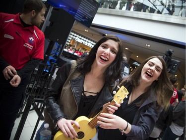 Erica Lapierre, 17, left, and her friend, Kellie-Anne Powell, 16, joke around with a ukulele.