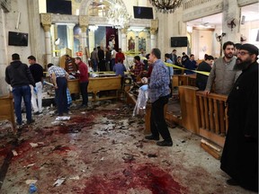 A general view shows people looking at the aftermath following a bomb blast which struck worshippers gathering to celebrate Palm Sunday at the Mar Girgis Coptic Church in the Nile Delta City of Tanta, 120 kilometres (75 miles) north of Cairo, on April 9, 2017.