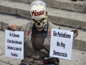 TOPSHOT - Journalists hold signs during a protest against the recent murder of the correspondent journalist Miroslava Breach, of La Jornada newspaper, at the Angel de la Indepencia in Mexico City, on March 25, 2017.  Breach, who investigated drug gangs, was found murdered earlier this week in Chihuahua, northern Mexico near the US border, with multiple gunshot wounds to the head. /