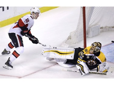 Boston Bruins goalie Tuukka Rask (40) looks up at Ottawa Senators center Ryan Dzingel (18) as the puck flies through the crease during the first period in Game 3 of a first-round NHL hockey playoff series in Boston, Monday, April 17, 2017.