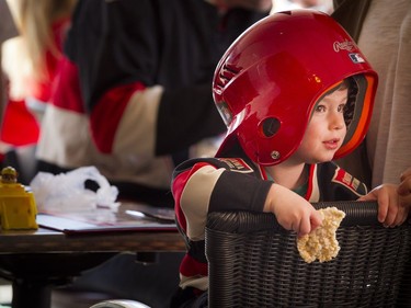 Two year old Mason Saray was watching the game while wearing his ball helmet and enjoying a rice crispy snack at St. Louis Bar and Grill on Elgin, along the Sens Mile Sunday April 23, 2017.   Ashley Fraser/Postmedia