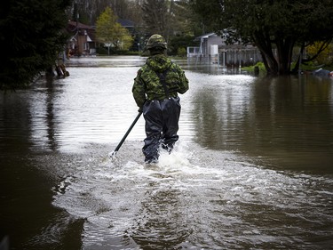 The Canadian Forces were called into Gatineau to help with the flooding in Gatineau Sunday May 7, 2017. A CF member makes his way into the flood waters along Rue Campeau Sunday afternoon.