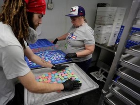 Thomas Slone, kitchen supervisor, left and kitchen associate Jamie Johnson, work on infusing candy with marijuana extract at the AmeriCanna Edibles facility in Boulder, Colo., on Tuesday, April 25, 2017.THE CANADIAN PRESS/Joe Mahoney