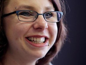 FILE - In this June 26, 2014, file photo, Michelle Knight smiles during an interview in Cleveland. Knight, held captive and tortured for more than a decade in a Cleveland home, is writing a follow-up to her best-selling memoir about her ordeal. Weinstein Books said Tuesday, May 9, 2017, that it will publish Knight‚Äôs ‚ÄúLife After Darkness: My Journey to Happiness.‚Äù The book is scheduled for May 2018. (AP Photo/Tony Dejak, File)