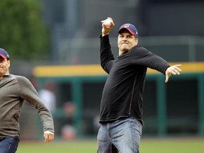 FILE - In this May 8, 2012, file photo, ESPN radio hosts Mike Greenberg, left, and Mike Golic throw out first pitches before a baseball game between the Cleveland Indians and the Chicago White Sox in Cleveland. The network announced Tuesday, May 16, 2017, that Greenberg would be leaving the longtime morning radio show he co-hosts with Golic to host a new morning TV show on ESPN TV that will premier Jan. 1. (AP Photo/Mark Duncan, File)