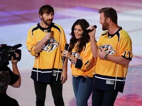 FILE - In this May 7, 2017 file photo, Dave Haywood, from left, Hillary Scott and Charles Kelley of Lady Antebellum performs the national anthem before Game 6 of a second-round NHL hockey playoff series between the Nashville Predators and the St. Louis Blues, in Nashville, Tenn. The longtime anthem singer at Nashville Predators hockey games has sour grapes over being replaced in the Stanley Cup playoffs by superstar singers such as Carrie Underwood, Luke Bryan, Lady Antebellum and Little Big Tow