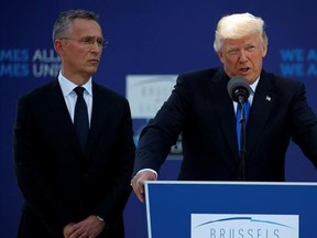 In this May 25, 2017, photo, NATO Secretary General Jens Stoltenberg listens as President Donald Trump speaks during a ceremony to unveil artifacts from the World Trade Center and Berlin Wall for the new NATO headquarters in Brussels. It‚Äôs been a muted week for Trump when it comes to tweeting. But AP Fact Checks have spotted some tall tales in his rhetoric during his first foreign trip since taking office. For one, Trump claimed that fellow NATO members ‚Äúowe massive amounts of money‚Äù to th