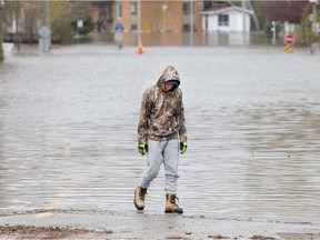 A local resident seems lost in thought after surveying a flooded Rue Saint-Louis in Gatineau as flooding continues throughout the region in areas along the local rivers.