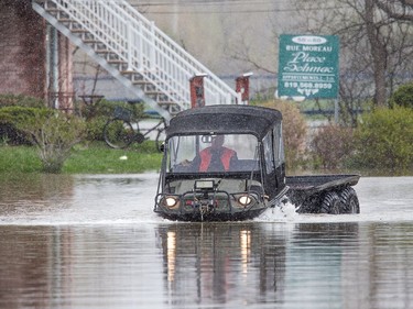 A man in an all terrain vehicle plows along Rue Moreau in Gatineau as flooding continues throughout the region in areas along the local rivers.