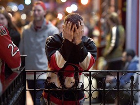 A Ottawa Senators fan puts his head in his hands after watching his team lose in double overtime during Game 7 of the Eastern Conference Final to the Pittsburgh Penguins, on Elgin Street's Sens Mile, in Ottawa on Thursday, May 25, 2017.
