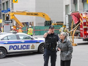 A police officer escorts a pedestrian out of the area of the gas leak.