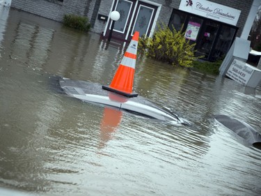A pylon marks a car almost entirely under water on Rue Saint-Louis, an area heavily affected by the flooding in the Gatineau Sunday May 7, 2017.
