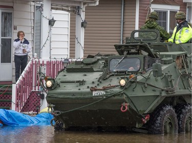 A woman chats to soldiers in an armoured vehicle along Rue Glaude in Gatineau as flooding continues throughout the region in areas along the local rivers.