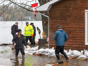 Allison Shields (left/centre) gets help from volunteers to sandbag around her property as the residents of Constance Bay deal with the Ottawa River rising to record levels and  flooding the region.  Wayne Cuddington/Postmedia