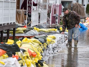 Andrew Merchand checks the sandbags in front of his home on Rue Glaude in Gatineau as flooding continues throughout the region in areas along the local rivers.