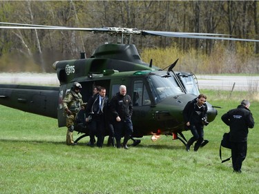 Quebec Premier Philippe Couillard (centre) arrives in a helicopter to tour flood-affected areas of the province in Luskville, Que., Monday, May 8, 2017.
