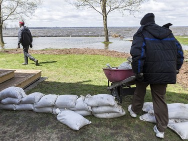 Courtney Roberts (R) and Bryson Patterson-Blasse help to place sandbags to protect a family friends house from flooding in Britannia Village in Ottawa. May 3,2017.