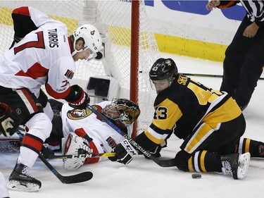 Ottawa Senators goalie Craig Anderson defends the goal as Ottawa Senators center Kyle Turris (7) and Pittsburgh Penguins left wing Conor Sheary (43) watch the puck during the third period of Game 7 of the Eastern Conference final in the NHL Stanley Cup hockey playoffs in Pittsburgh, Thursday, May 25, 2017.