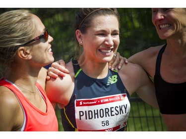 Dayna Pidhoresky (centre) was the top Canadian female finisher in the marathon Sunday May 28, 2017 at the Tamarack Ottawa Race Weekend. Pidhoresky was greeted by friends and fellow racers including L-R Natasha Wodak and Catherine Watkins after she finished.