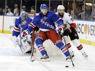 New York Rangers' Derek Stepan (21) and Ottawa Senators' Zack Smith (15) compete for control of the puck as goalie Henrik Lundqvist (30) watches during the first period of Game 3 of an NHL hockey Stanley Cup second-round playoff series Tuesday, May 2, 2017, in New York.