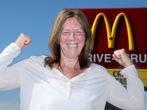 Esther Brake, the longtime McDonalds manager who was recently awarded a $100k judgement in her wrongful dismissal case, stands victorious outside a set of Golden Arches in Ottawa.