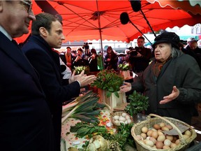 Emmanuel Macron, now the French president, speaks with a vendor on April 29, 2017 on a market in Poitiers, central France, while campaigning. The markets, writes Andrew Cohen, are but one symbol of France's beauty and culture.