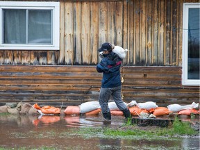 Firefighter Allison Davis volunteers to help sandbag around a property as the residents of Constance Bay deal with the Ottawa River rising to record levels and  flooding the region.
