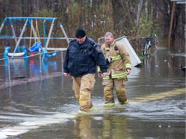 Firefighters check on a flooded home as the residents of Constance Bay deal with the Ottawa River rising to record levels and  flooding the region.
